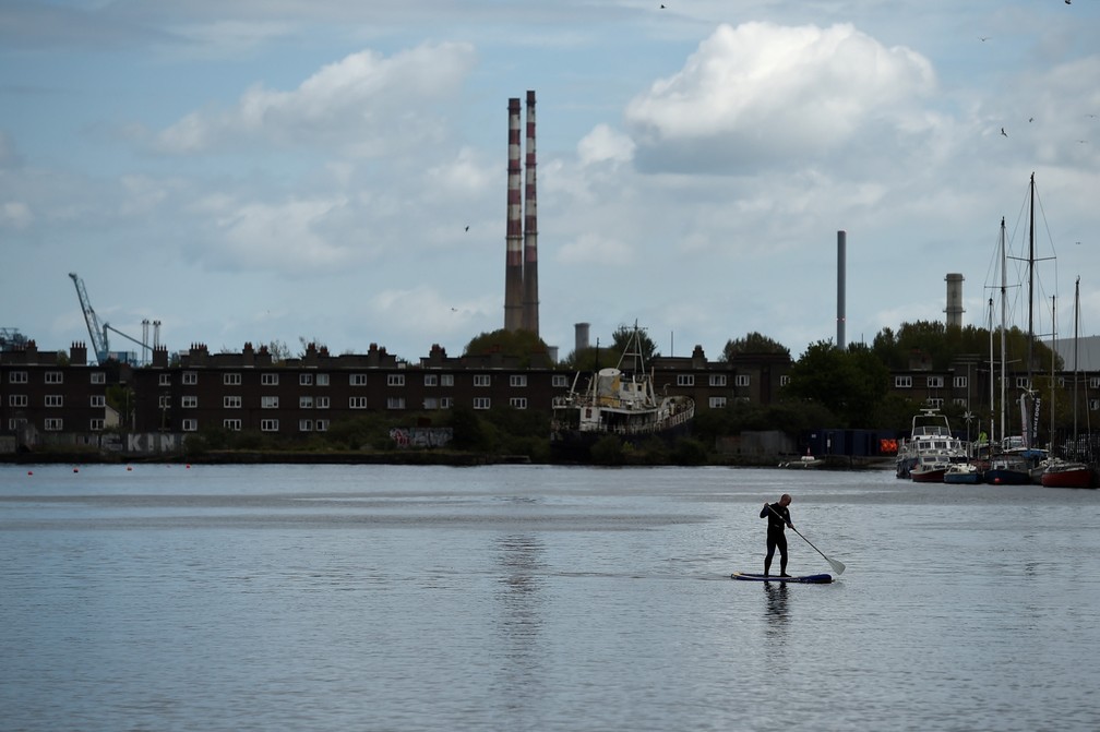 Um homem pratica stand-up paddle na região das docas em Dublin, na Irlanda — Foto: Clodagh Kilcoyne/Reuters