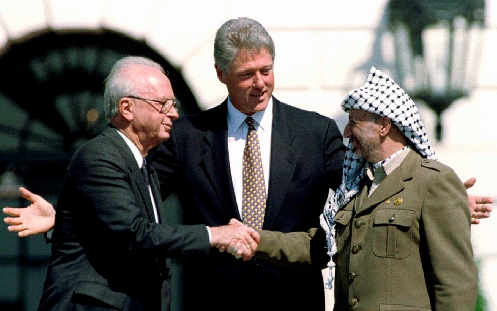 Bill Clinton, ao centro, assiste ao primeiro-ministro de Israel, Yitzhak Rabin, cumprimentar o presidente da Organização para a Liberação da Palestina, Yasser Arafat, em setembro de 1993 — Foto: Gary Hershorn/Arquivo/Reuters