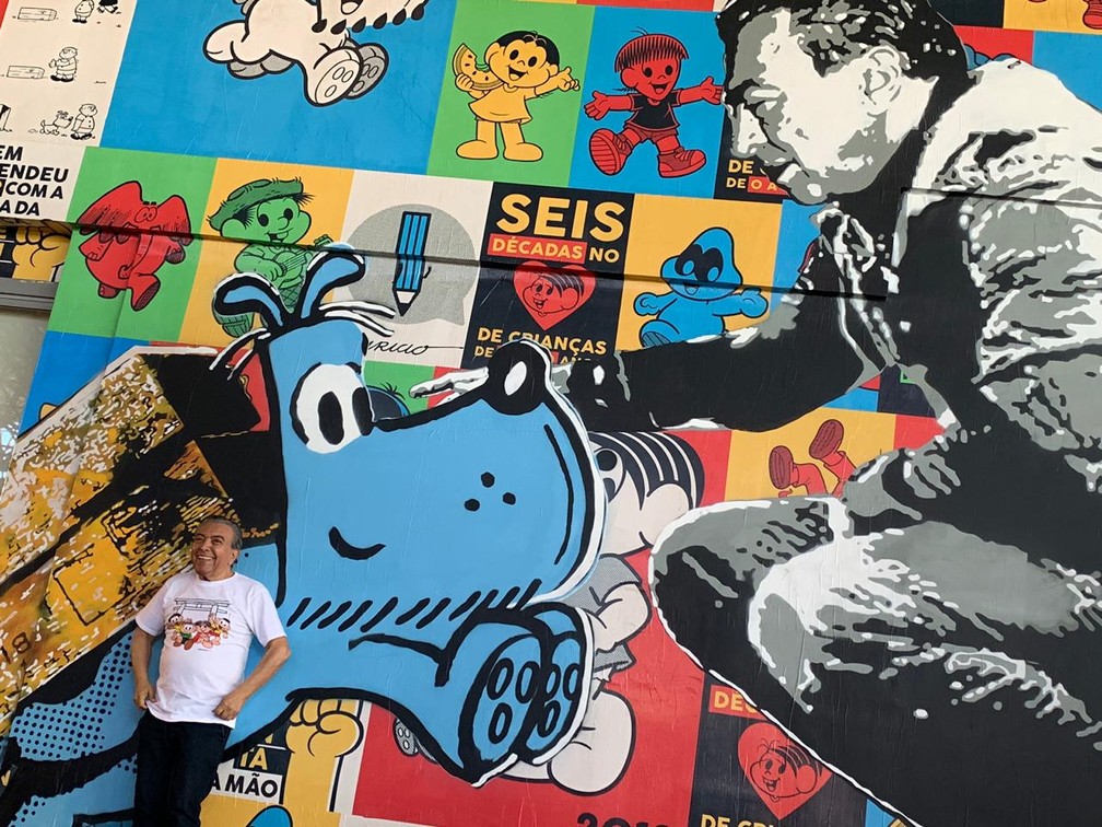 Mauricio de Sousa posa diante de painel em sua homenagem na Bienal â Foto: Fernanda Rouvenat/G1