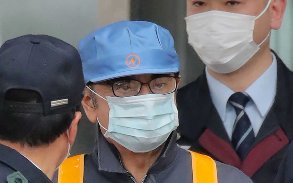 O ex-presidente da Nissan, Carlos Ghosn deixou a Casa de Detenção de Tóquio com o rosto coberto por máscara e usando macacão — Foto: Jiji Press / AFP Photo