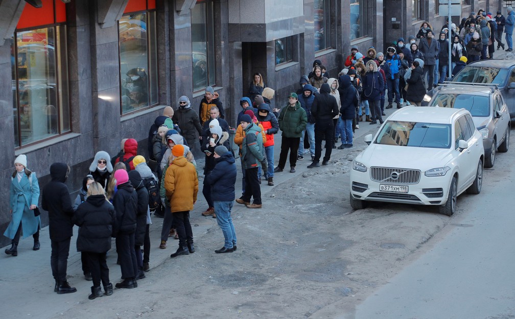 27 de fevereiro - Russos fazem fila para usar um caixa eletrônico em São Petersburgo, na Rússia. O rublo, moeda russa, caiu para uma baixa recorde em relação ao dólar nesta segunda-feira (28), depois que nações ocidentais anunciaram um conjunto de sanções duras no fim de semana para punir a Rússia por sua invasão da Ucrânia — Foto: Anton Vaganov/Reuters