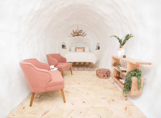 O interior tem uma pegada escandinava na decoração, contando com cama, e sala de estar moderninhos (Foto: Airbnb/ Reprodução)