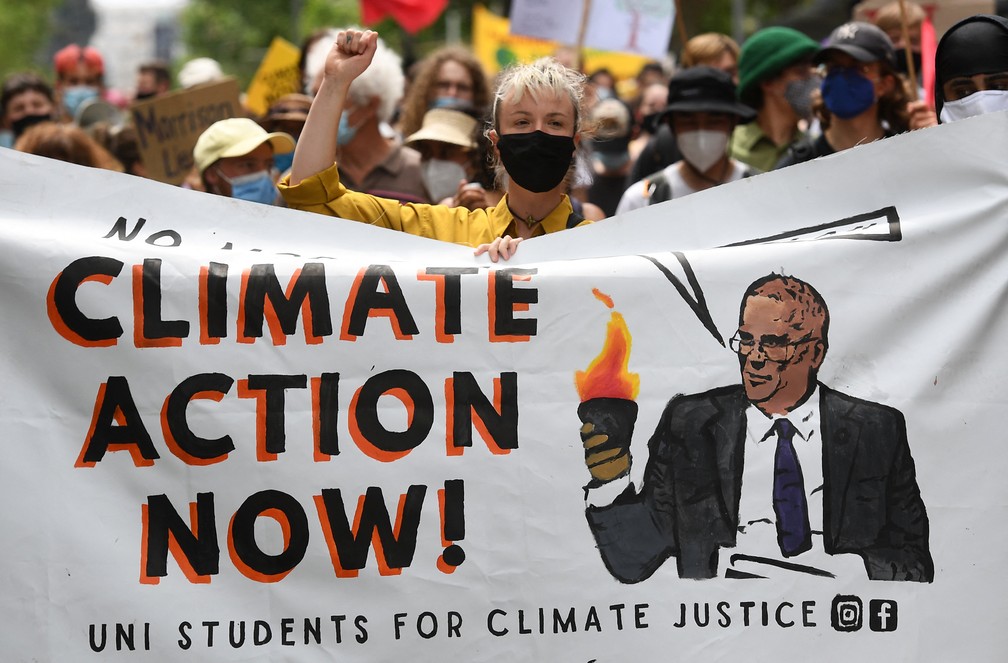 Manifestante segura cartaz contra o primeiro-ministro da Austrália, Scott Morrison, em uma manifestação durante um dia global de ação sobre mudança climática em Melbourne, neste sábado (6), enquanto líderes mundiais participam da Conferência sobre Mudança Climática da ONU, a COP26, em Glasgow, na Escócia. — Foto: William West / AFP