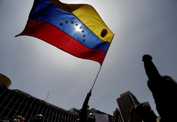 Manifestante empunha bandeira da Venezuela durante marcha contra o governo de Nicolás Maduro em Caracas (Foto: Marco Bello/Reuters)