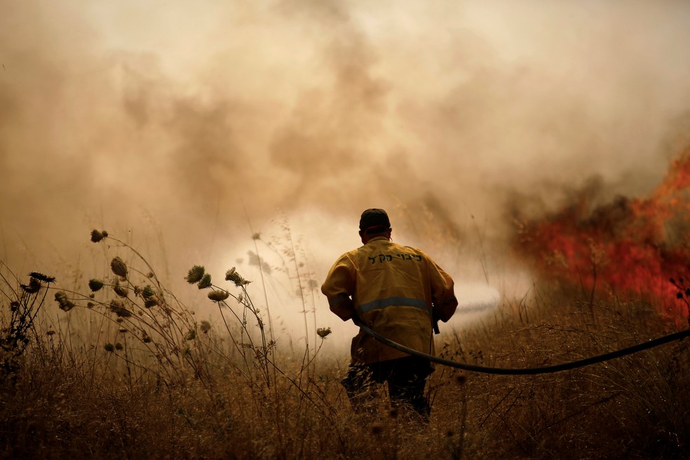 Bombeiro tenta combater fogo na fronteira entre Israel e Gaza (Foto: Amir Cohen/Reuters)