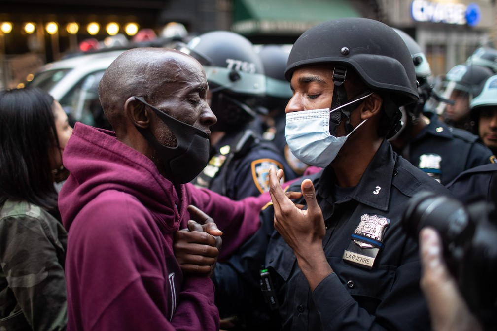 2 de junho - Um manifestante e um policial dão as mãos durante uma manifestação em protesto contra a morte de George Floyd em Nova York, nos EUA — Foto: Wong Maye-E/AP