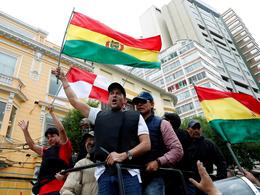 Liderança política em Santa Cruz, Luis Camacho desfila pelas ruas de La Paz com apoiadores que seguram bandeiras da Bolívia na terça-feira (11) — Foto: Carlos Garcia Rawlins/Reuters