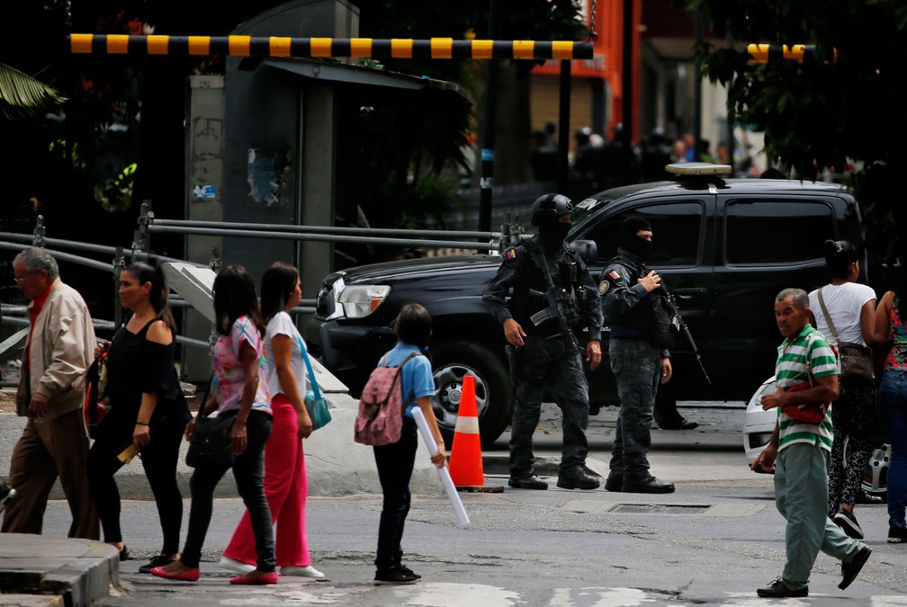 Agentes mascarados da agência de inteligência da polícia venezuelana montam guarda na entrada da Assembleia Nacional da Venezuela nesta terça-feira (14) — Foto:  Fernando Llano/ AP