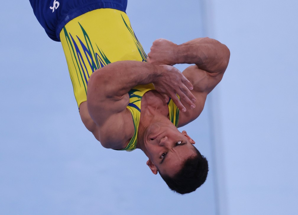 Caio Souza, ginasta brasileiro, faz careta durante acrobacia — Foto: Reuters