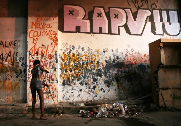 Mulher varre chão de ocupação na favela da Mangueira, no Rio de Janeiro (Foto: Mario Tama/Getty Images)