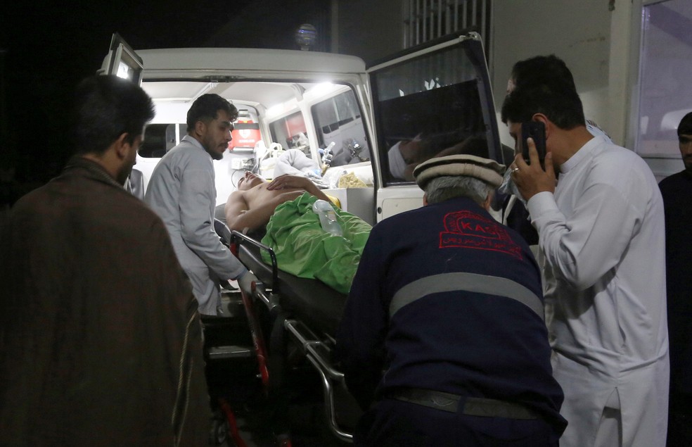 Homem é levado para o hospital após explosão durante festa de casamento em Cabul, no Afeganistão — Foto: AP Photo/Nishanuddin Khan