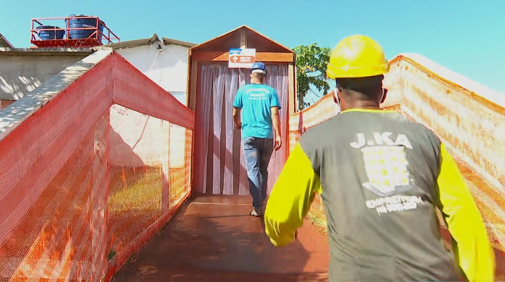 Trabalhadores da construção civil passam por túnel de desinfecção antes de entrar em obra de Ribeirão Preto — Foto: Ronaldo Gomes/EPTV
