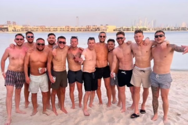 Andy Carroll (à direita) com amigos em sua despedida de solteiro em Dubai, que terminou com ele deitado numa cama com uma mulher que não é a sua noiva (Foto: reprodução)