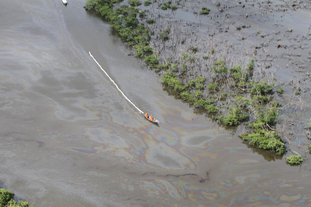 Barco circula em meio ao óleo que vazou de duto da Petrobras no Rio Estrela â€” Foto: Mário Moscatelli/ Projeto Olho Verde