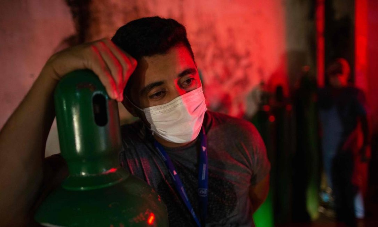 Um homem segura um tanque de oxigênio em Manaus. O sistema de saúde da capital amazonense está em colapso. Unidades de tratamento intensivo do hospital da cidade estão com 100% da capacidade nas últimas duas semanas, enquanto os profissionais da área médica lutam contra a falta de oxigênio e outros equipamentos essenciais — Foto: MICHAEL DANTAS / AFP