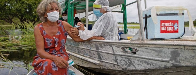 Olga D'arc Pimentel, 72 anos, é vacinada contra Covid-19, na comunidade Nossa Senhora Livramento, às margens do Rio Negro, perto de Manaus, Amazonas — Foto: MICHAEL DANTAS / AFP