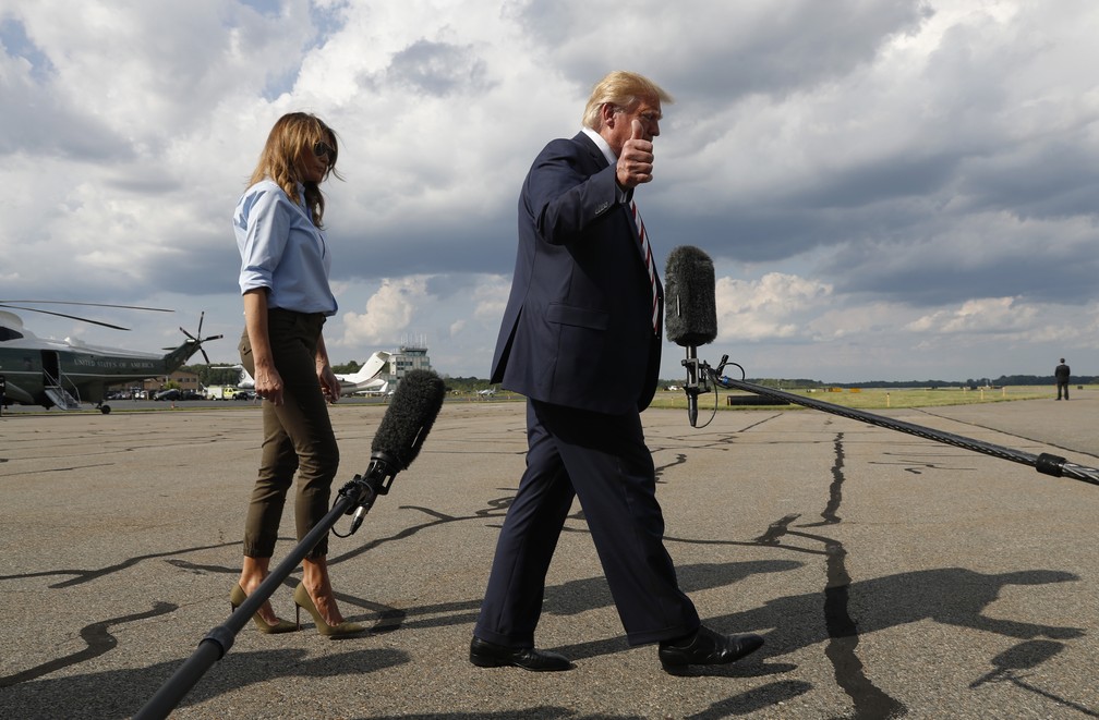 O presidente americano, Donald Trump, e a esposa, Melania, andam em direção à imprensa antes de o presidente falar neste domingo (4), em Morristown, Nova Jérsei. — Foto: Jacquelyn Martin/AP