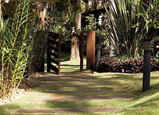 À esq., a orquídea-bambu (4) contorna o caminho que leva à entrada do jardim. Despertando cor com suas folhas avermelhadas, o lambari-roxo (6) cria uma bordadura para os lírios-de-são-josé (5) e os fórmios (3) (Foto: Casa e Jardim)