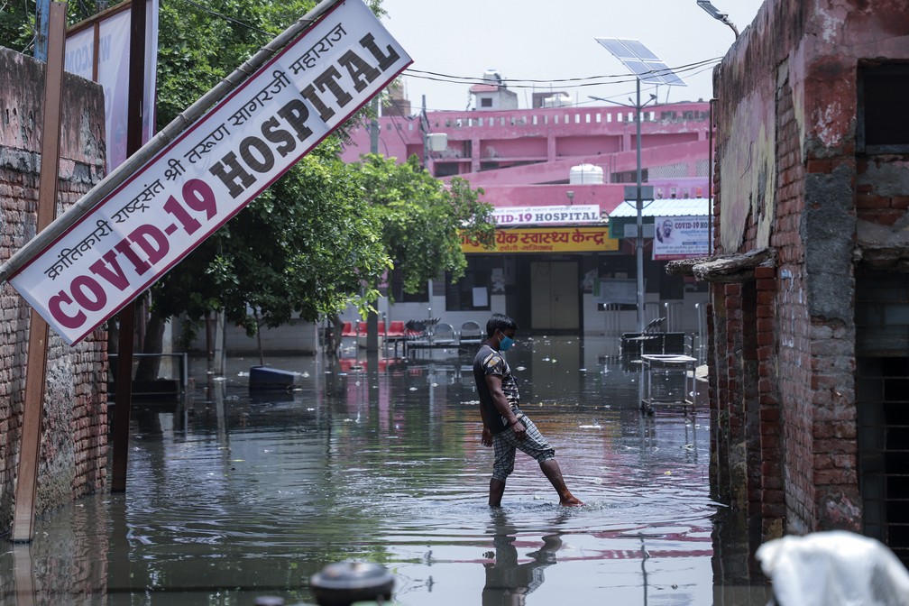 Trabalhador tenta tirar água depois que fortes chuvas inundaram as instalações de um hospital para a Covid-19 que está sendo instalado em Ghaziabad, nos arredores de Nova Delhi, na Índia, no domingo, 23 de maio de 2021. O hospital ainda não está funcionando. — Foto: Amit Sharma/AP