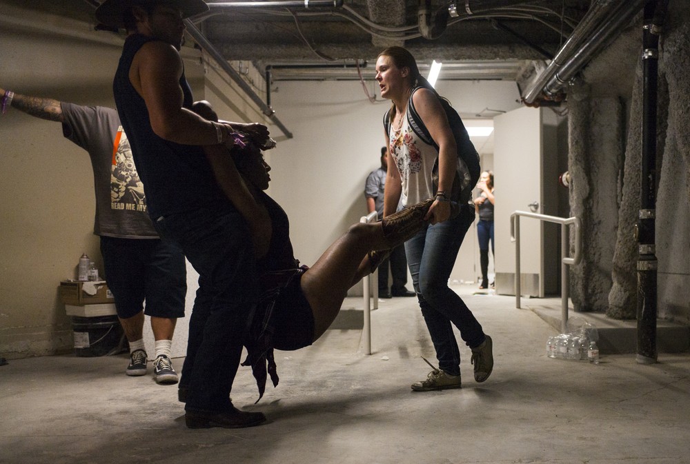 Pessoas carregam mulher ferida durante festival de música country em Las Vegas em que centenas de tiros foram disparados (Foto: Chase Stevens/Las Vegas Review-Journal via AP)