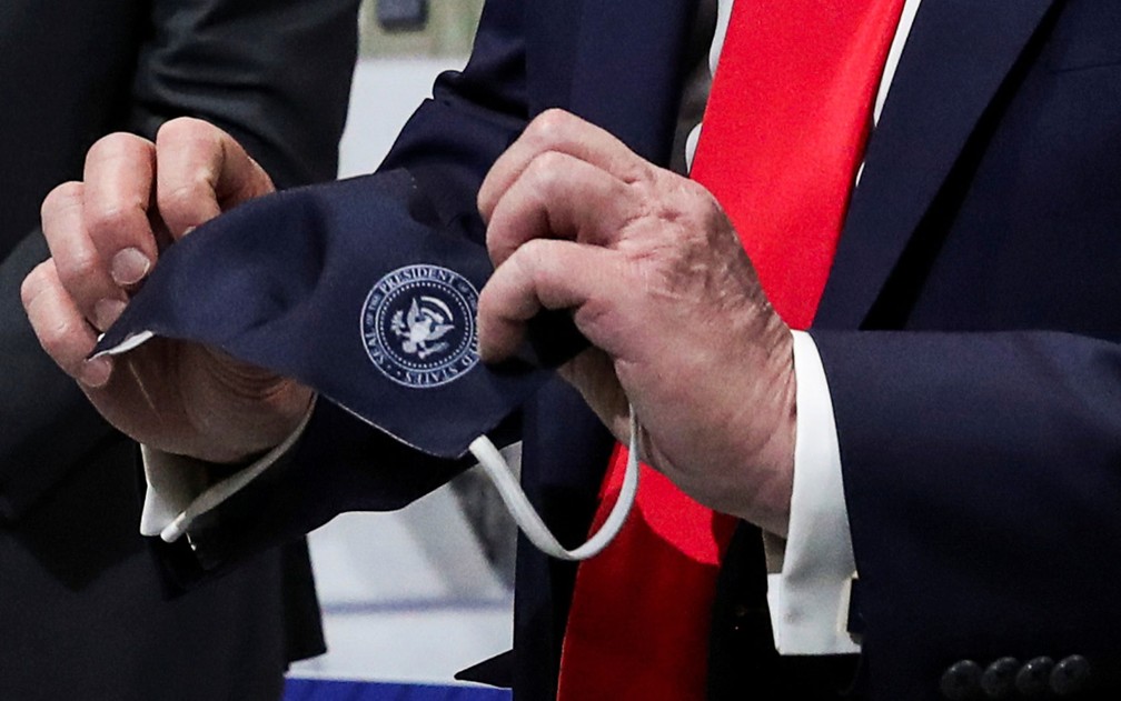 O presidente dos EUA, Donald Trump, segura uma máscara com o selo presidencial que disse ter usado durante visita à fábrica de componentes da Ford em Ypsilanti, Michigan, em 21 de maio — Foto: Reuters/Leah Millis 