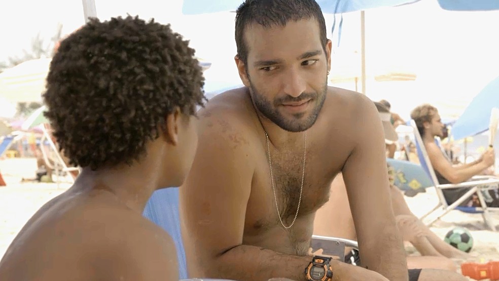 Tiago (Pedro Guilherme Rodrigues) convence Sandro (HUmberto Carrão) a ficar mais um pouquinho na praia em 'Amor de Mãe' — Foto: Globo