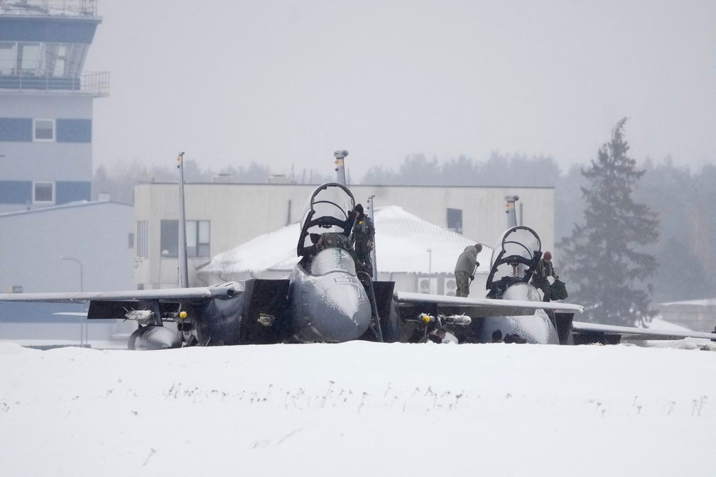 Militares da Força Aérea dos EUA inspecionam caças F-15 no aeródromo militar de Amari, na Estônia, em 1º de fevereiro de 2022 — Foto: Ints Kalnins/Reuters