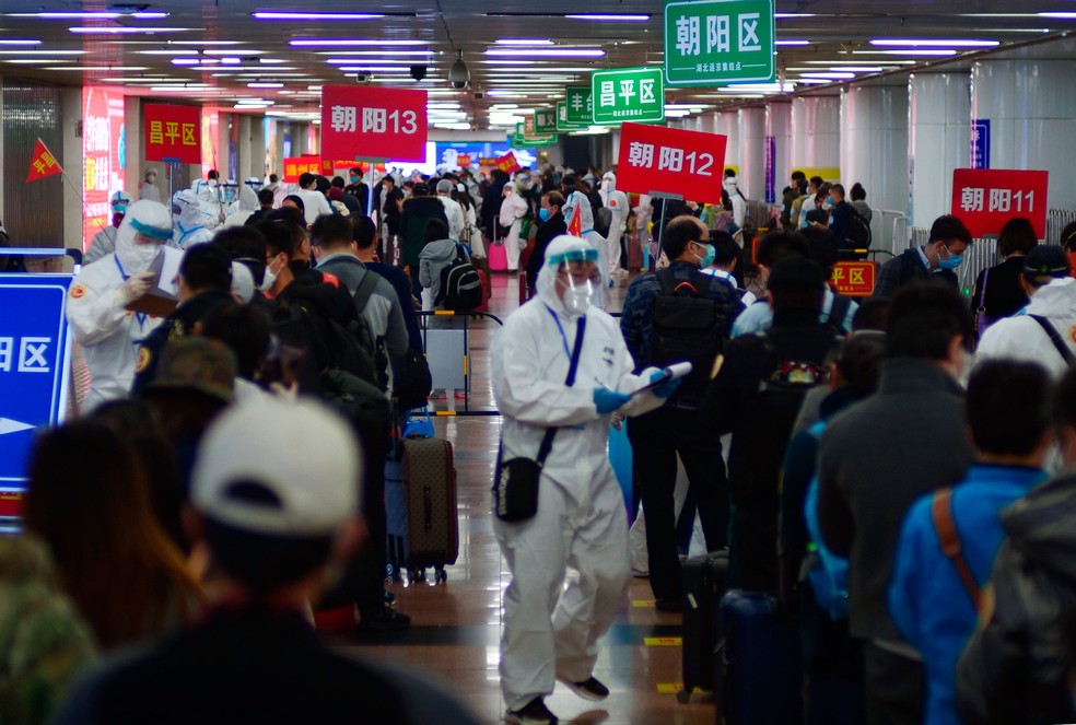 Passageiros de Wuhan, na China, esperam em filas para mostrar que cumpriram a quarentena em Pequim na quarta-feira (15)  — Foto: Sam McNeil/AP