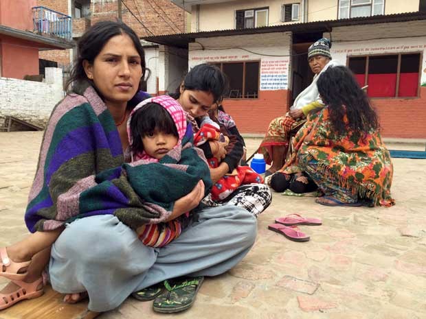 Mães e filhos deixam suas casas e esperam em uma escola após forte terremoto atingir o Nepal e a Índia. (Foto: Navesh Chitrakar / Reuters)