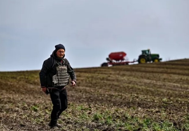 Um agricultor usa um colete à prova de balas durante a semeadura da primavera na região de Zaporizhzhia (Foto: GETTY IMAGES via BBC)
