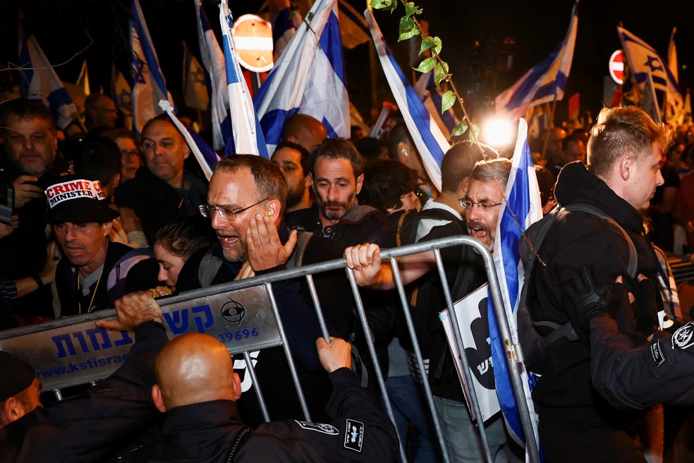 Manifestantes empurram grades e são contidos pela polícia em Jerusalém — Foto: Reuters/Ronen Zvulun 