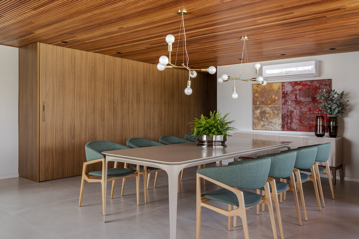 SALA DE JANTAR | O pé direito duplo do ambiente valoriza os volumes da construção. O mobiliário da parte interna da casa é da Home Design (Foto: Divulgação / Gabriela Daltro)