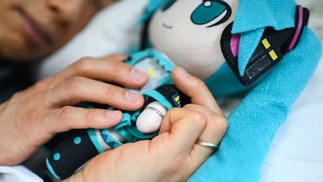 Akihiko Kondo dorme abraçado a uma boneca de Hatsune Miku, a estrela pop virtual com quem se casou em 2018NYT