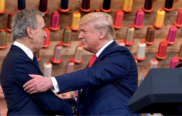 A presença de Trump (ao lado de Arnault) na fábrica da Louis Vuitton foi criticada por Shannon e pelo diretor de criação da marca (Foto: Nicholas Kamm / AFP)