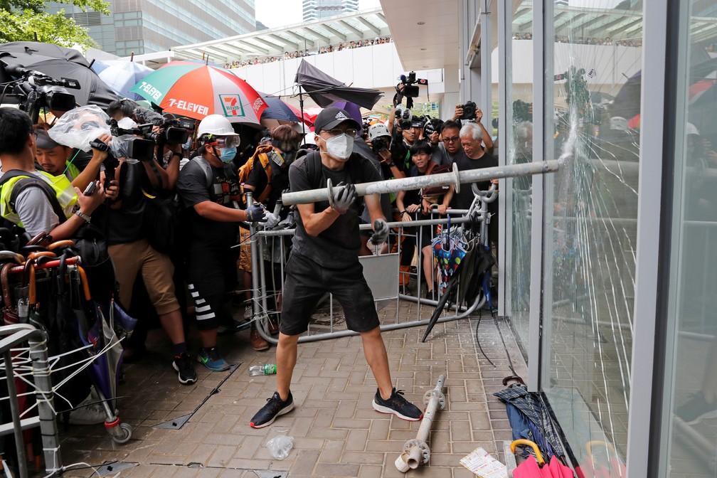 Manifestante tenta estourar porta de vidro do Parlamento de Hong Kong — Foto: REUTERS/Tyrone Siu