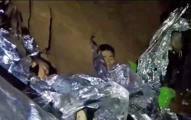 Meninos presos em caverna na Tailândia descansam após ganharem cobertores térmicos (Foto: Marinha Tailandesa / via REUTERS)