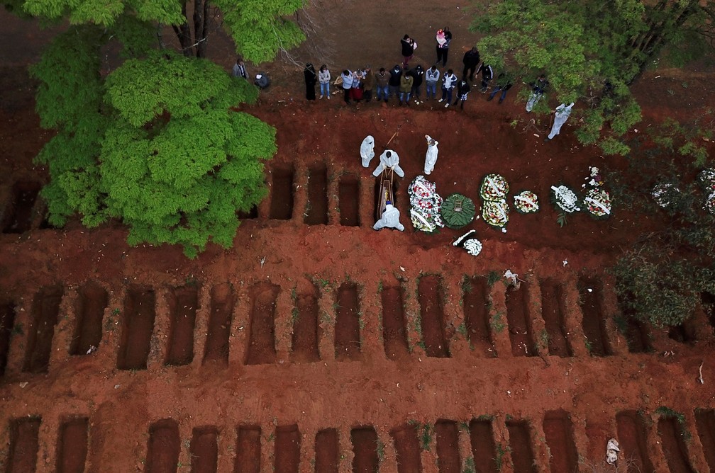 16 de julho de 2020: coveiros com roupas de proteção enterram caixão no cemitério da Vila Formosa, em São Paulo, durante a pandemia do novo coronavírus (COVID-19) no Brasil — Foto: Amanda Perobelli/Reuters