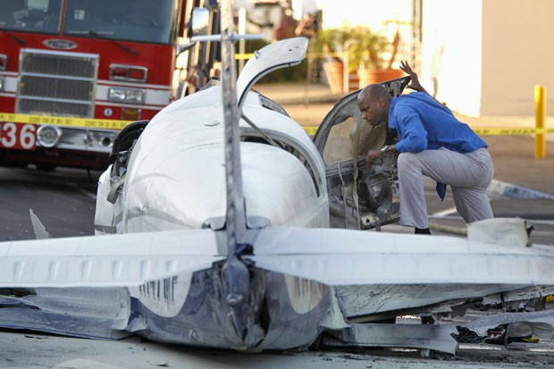 Inspetor de aviação analisa pequeno avião que caiu em estacionamento de shopping em San Diego, nos EUA, nesta quarta-feira (30) (Foto: UT San Diego, Hayne Palmour IV/AP)