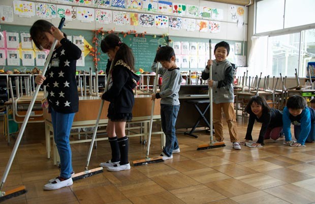 Reunidos em grupos, alunos se revezam na tarefa de limpar a escola no Japão. (Foto: Marcelo Hide/BBC)