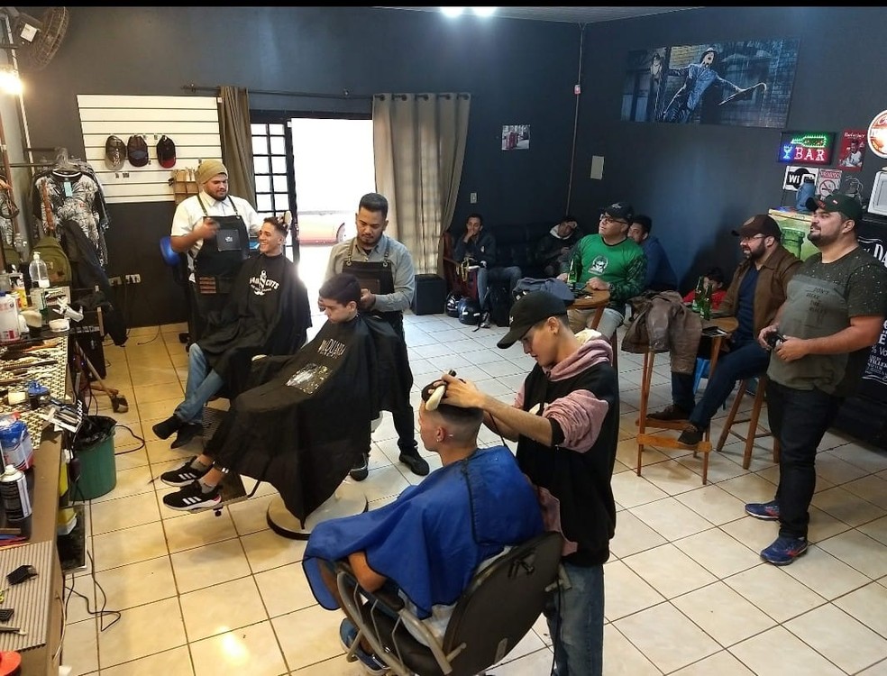 Barbeiros e os filhos atendendo aos clientes em barbearia de MS — Foto: Fernando Duarte/Arquivo Pessoal