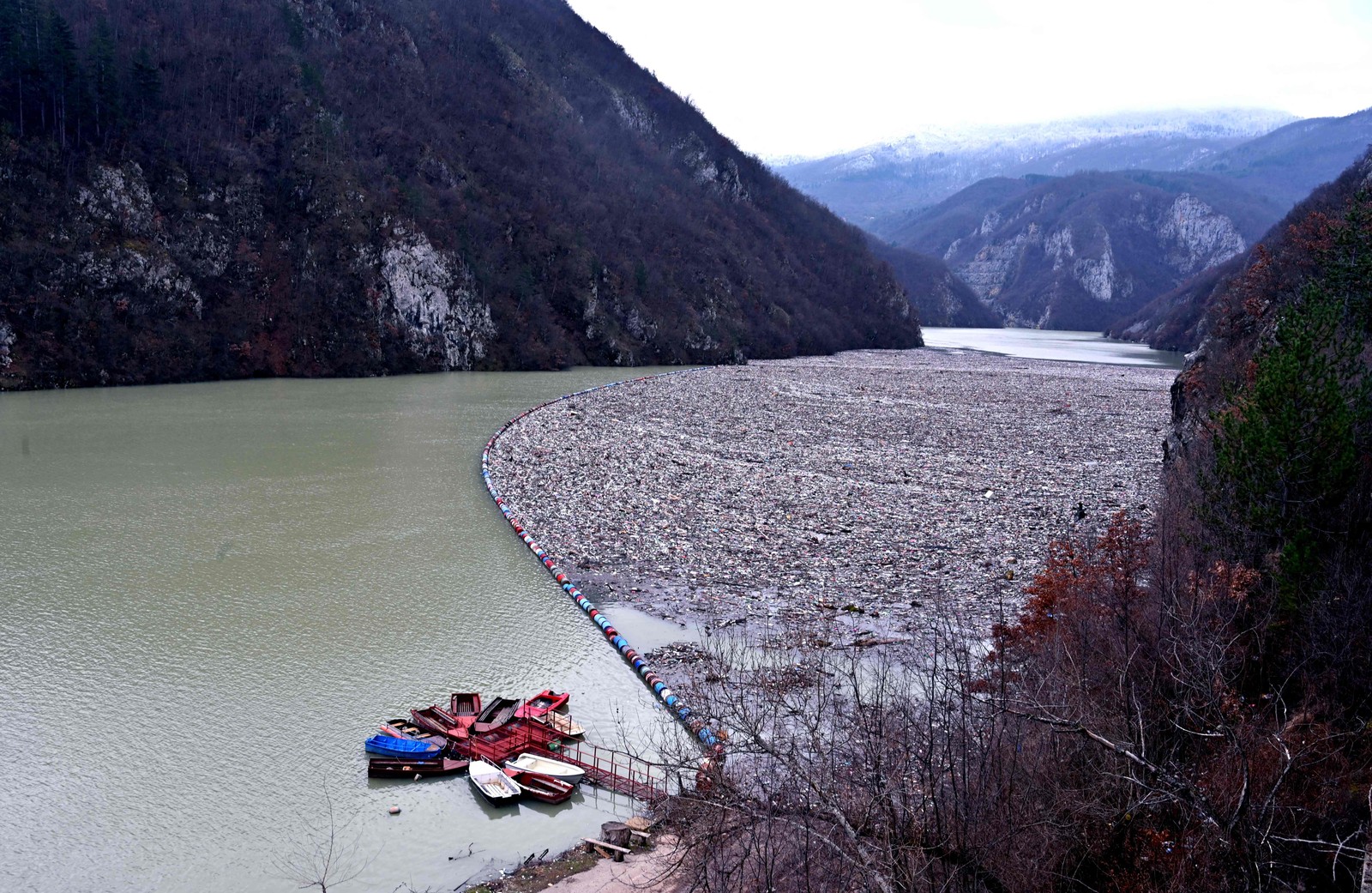 Resíduos e detritos flutuam atrás de uma barreira no rio Drina, perto de Visegrad, leste da Bósnia e Herzegovina.  — Foto: ELVIS BARUKCIC / AFP