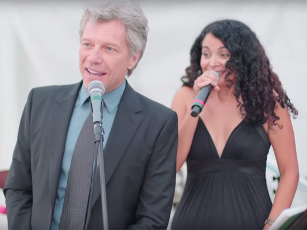 De cabelos grisalhos, Jon Bon Jovi dá canja ao lado da cantora Lourdes Valentin em casamento no final de semana; eles cantaram versão 'jazzística' do hit 'Livin' on a prayer' (Foto: Reprodução/YouTube/Cool Coconut Studios)