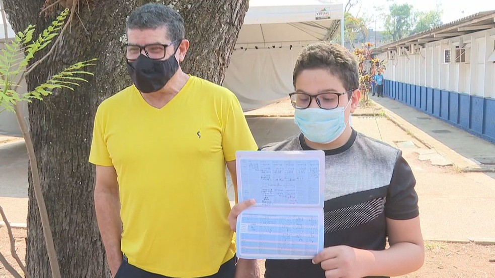 Pai leva filho para tomar vacina contra Covid-19, no DF — Foto: TV Globo/Reprodução