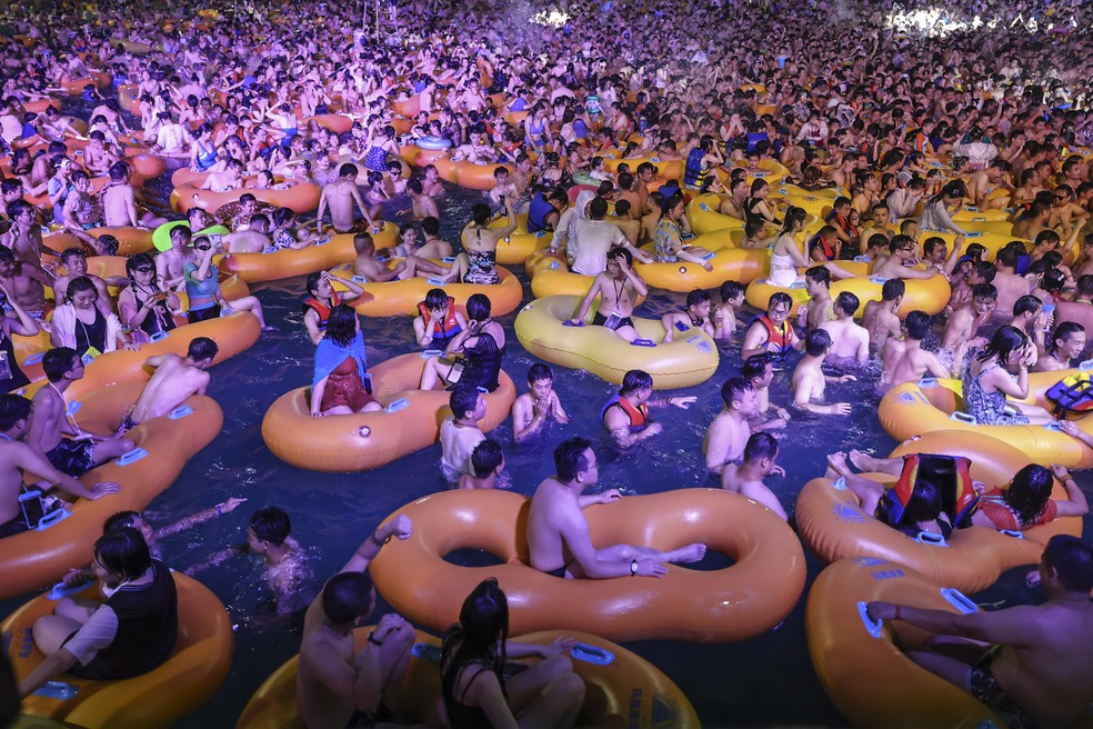 Pessoas participam de uma festa em um parque aquático em Wuhan, na província de Hubei, na China, no sábado (15) — Foto: AFP