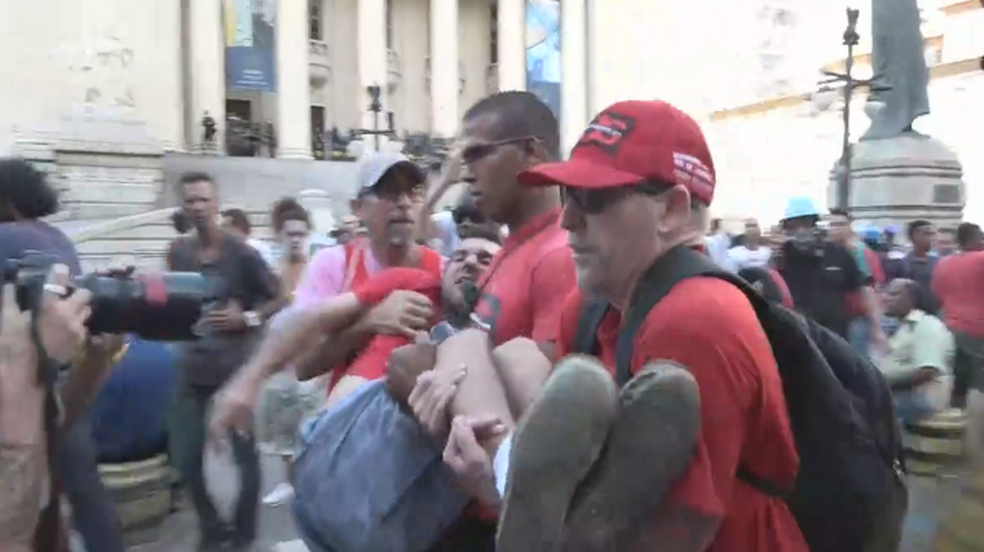 Manifestante é retirado durante tumulto (Foto: Reprodução/G1)