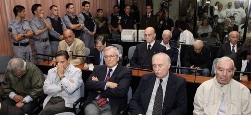 Quinze acusados no primeiro julgamento do circuito ABO — na foto, Kalinec olha suas anotações na segunda fileira, o segundo a partir da esquerda — Foto: CIJ/Via BBC