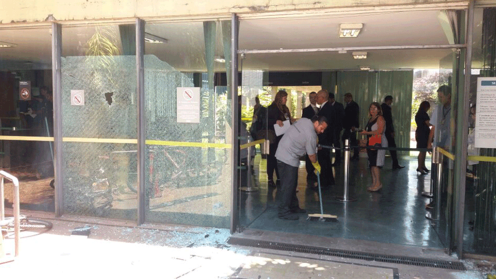 Vidros da entrada do prédio foram quebrados durante confronto (Foto: PMDF/Divulgação)