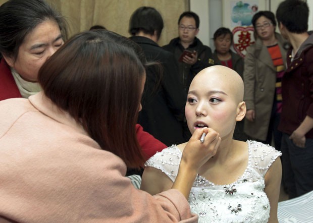 Fan Huixiang, é maquiada antes de seu casamento. Ela usou uma peruca (Foto: China Daily/Reuters)