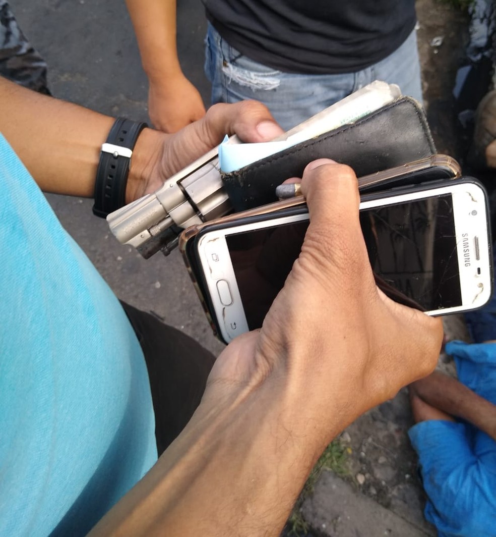 Arma, celulares e carteira foram apreendidos com os suspeitos — Foto: Divulgação/PM