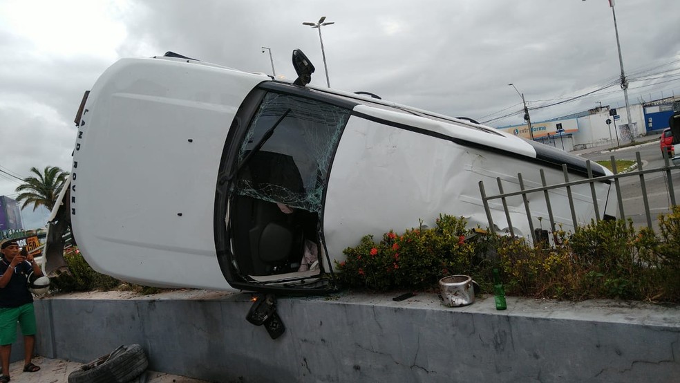 Após o acidente, o carro ficou pendurando de lado no muro — Foto: Jean Silva